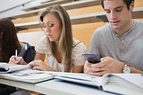 Student using smartphone in lecture hall