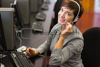 Teacher sitting at the computer wearing a head set