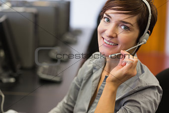 Teacher sitting at the computer room wearing headset