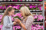 Mother and daughter smelling plant