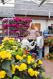 Woman and child taking a flower pot from employee