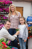 Mother and daughter receiving flower pot from employee