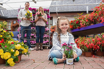 Family holding flower pots in garden center