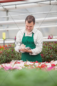 Man taking notes in greenhouse
