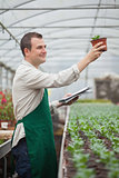 Gardener looking happily at seedling while taking notes