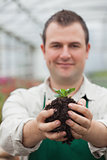 Man holding a plant with soil in his hands
