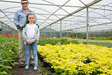 Little girl with grandfather in greenhouse