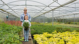 Gardener and granddaughter holding a large potted plant