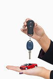 Woman holding key and small car