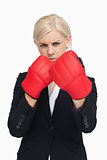 Serious businesswoman wearing red boxing gloves