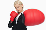 Serious businesswoman with red gloves fighting