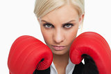 Serious green eyed woman with red gloves fighting