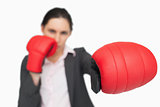 Serious brunette wearing red gloves punching