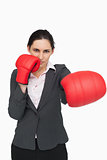 Serious brunette wearing red gloves while punching