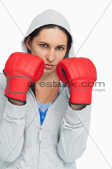 Brunette in sweatshirt wearing boxing gloves