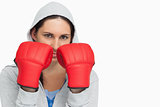 Brunette woman in sweatshirt wearing boxing gloves