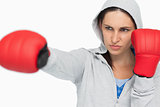 Combative brunette in sweatshirt boxing