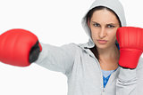 Stern woman in sweatshirt boxing