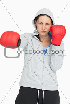 Brown haired woman in sweatshirt boxing