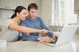 Young couple seeing something interesting on laptop