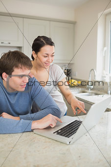 Happy couple looking at laptop