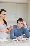 Woman cutting up credit card with man calculating finances