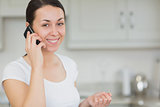 Woman calling with the mobile phone in the kitchen