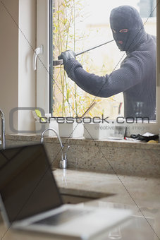 Burglar opening window with crow bar