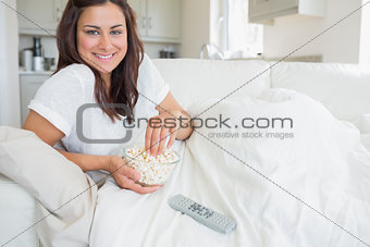 Smiling woman eating popcorn