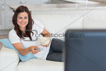 Brunette smiling while watching television