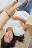 Woman lying between moving boxes