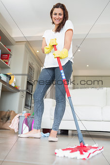 Brunette woman mopping the floor