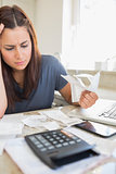 Brunette looking worried and holding bills