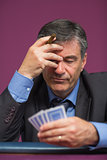 Man holding his cards thinking