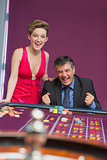 Man and woman cheering at roulette table