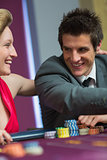 Couple smiling at each other at roulette table