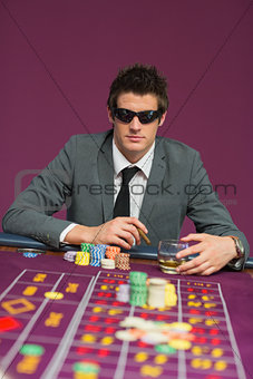 Man wearing sun glasses at roulette table