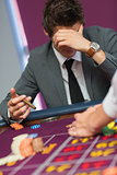 Man with cigar thinking at roulette table