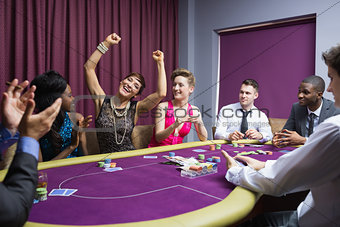 People cheering at poker table