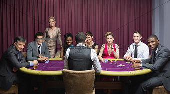 Smiling group sitting around poker table