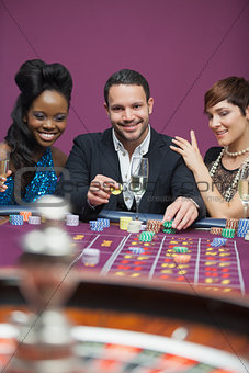 Man playing roulette with two women