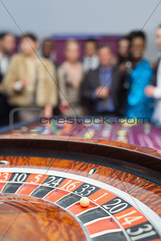 People standing looking at the roulette wheel