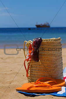 sunbathing accessories in straw bag