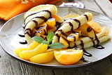 thin pancakes (crepes) with peaches and chocolate sauce