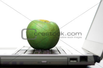 Green apple on an open laptop computer