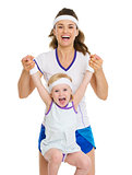 Portrait of happy mother and baby in tennis clothes