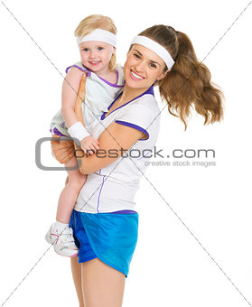 Portrait of happy mother and baby in tennis clothes