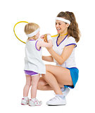 Happy mother showing baby medal for achievements in tennis