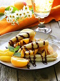 thin pancakes (crepes) with peaches and chocolate sauce
