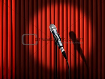 Microphone under spotlight over red curtains